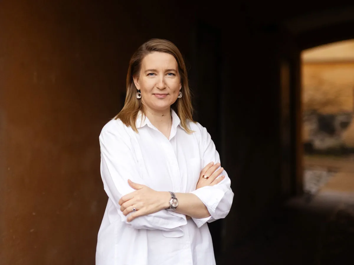 Johanna Vuorelma katsoo kameraan kädet ristissä.